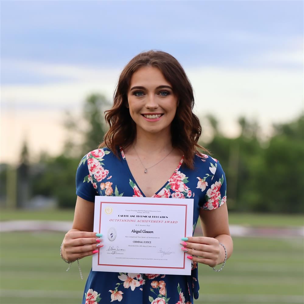 A student displays her certificate of achievement at the 2023 CTE Graduation.