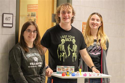 Students pose for a photo with toys